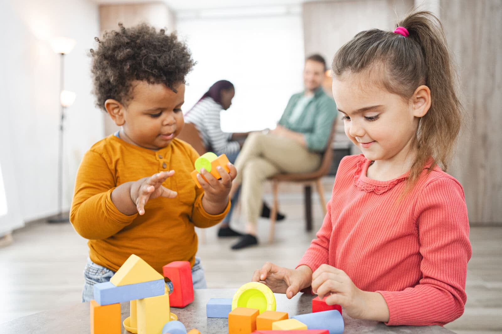 Young children playing with colorful building blocks