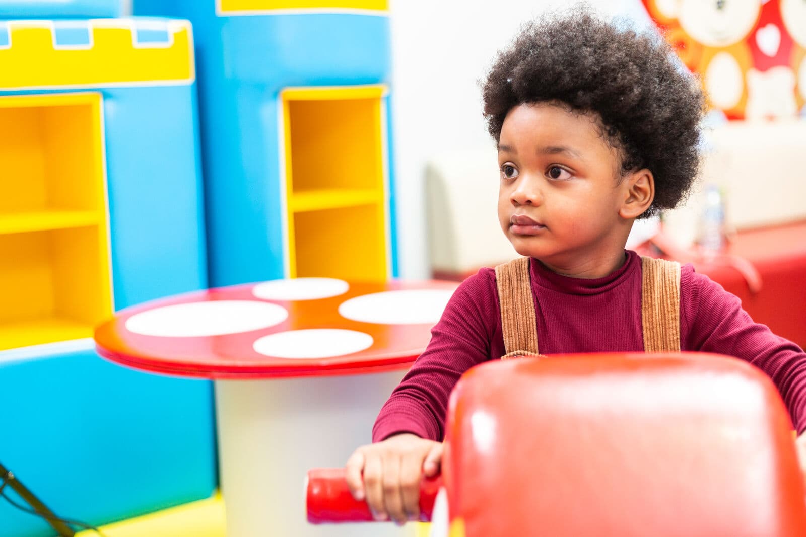 A child riding a toy in the playroom