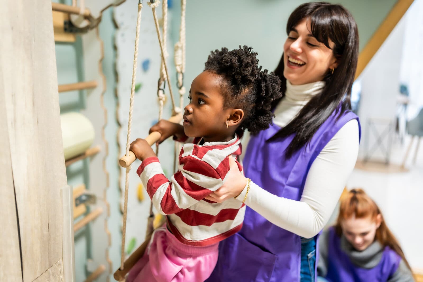 A young girl on indoor climbing equipment